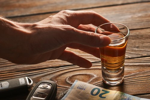 mens-hand-reaching-to-alcohol-glass