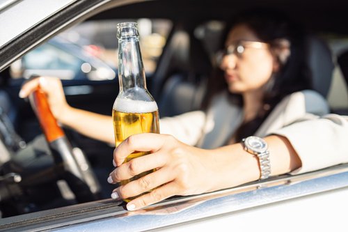 woman-drinks-beer-in-parked-car